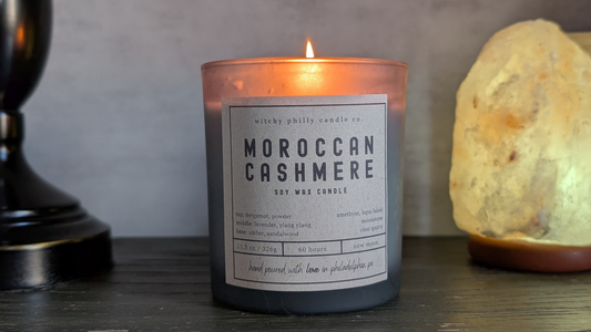 lit moroccan cashmere candle with a salt lamp on a bedside table