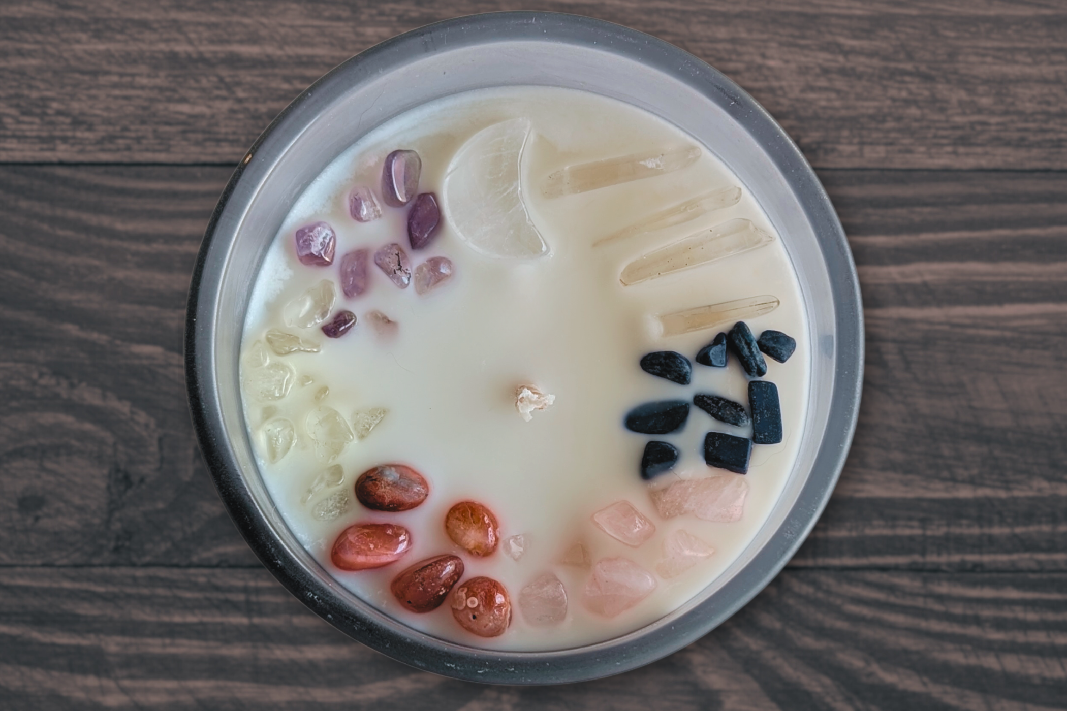 amethyst, citrine, carnelian, rose quartz, clear quartz, and lapis lazuli crystals on a cinnamon vanilla candle